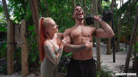 Rossa tatuata seduce stallone muscoloso in palestra tropicale